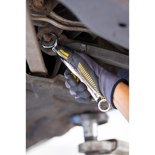 Photo of STANLEY STMT82842-0 wrench in gloved hand tightening bolt under vehicle.
