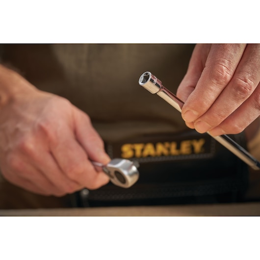 Photo of STANLEY STMT86007-0 ratchet and socket, close-up in hand, with tool belt visible.