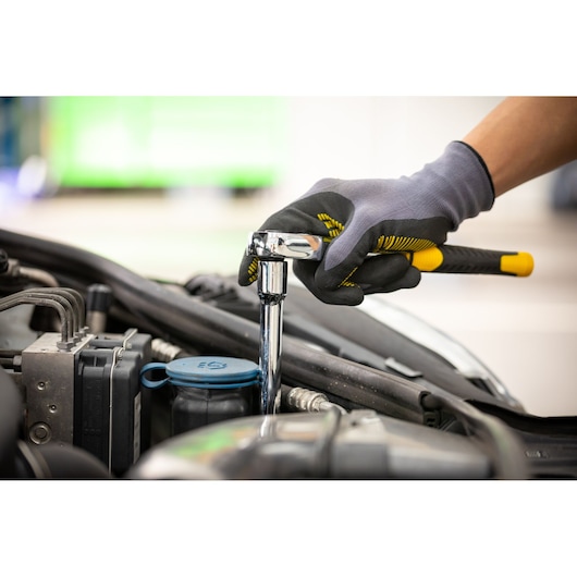 Stanley STMT86007-0 ratchet wrench in use on car engine, close-up photography.