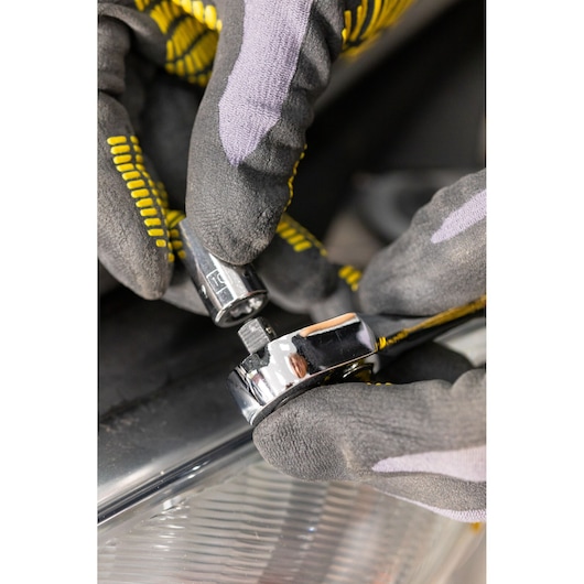 STANLEY STMT86111-0 socket being attached to ratchet wrench, close-up photo with gloved hands.