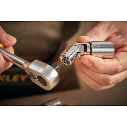 Photo of STANLEY STMT86211-0 socket and ratchet, close-up of hands connecting chrome tool parts.