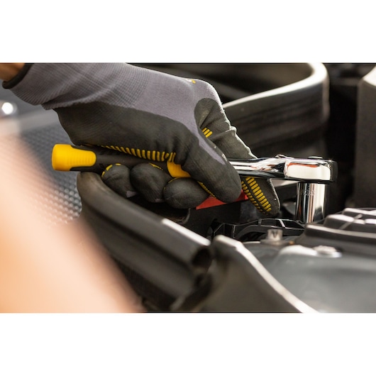 STANLEY STMT86303-0 ratchet wrench in use, close-up, held by gloved hand during automotive repair.