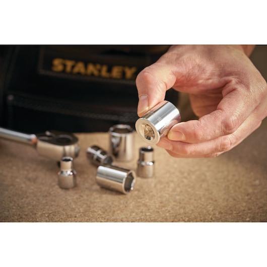 STANLEY STMT86311-0 socket set photography, silver sockets on table with hand holding one.