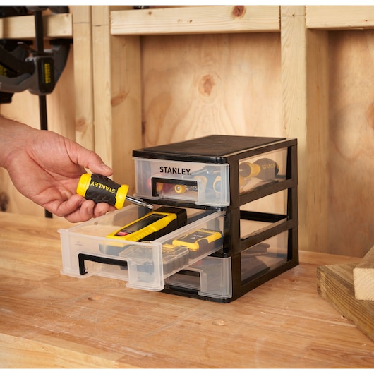 STANLEY STST40710-1 drawer organizer with three clear drawers, shown on a workbench, storing hand tools.