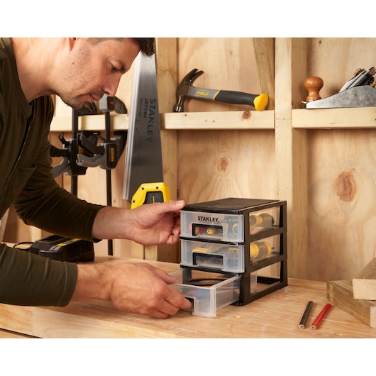 Photo of STANLEY STST40710-1 storage drawers on a workbench, filled with hand tools in a workshop.