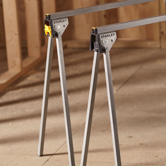 STANLEY STST81337-1 folding saw horse pair with metal legs, angled view, photography in workshop.