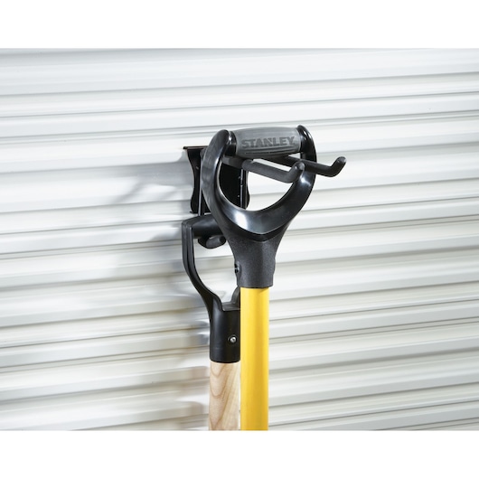 STANLEY STST82606-1 black steel wall-mounted tool holder with yellow-handled tool, side angle.