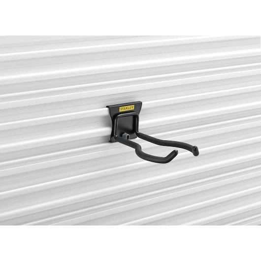 STANLEY STST82609-1 black steel utility hook mounted on white grooved wall, side angle.