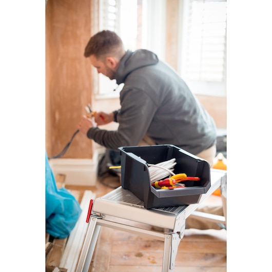 STANLEY STST82741-1 black open tool box with tools and cables, photo on work site surface.