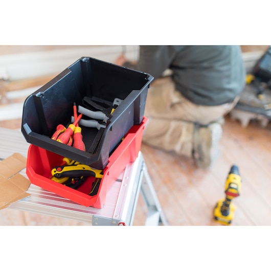 STANLEY STST82741-1 red and black stackable tool box with hand tools, front angle on ladder.