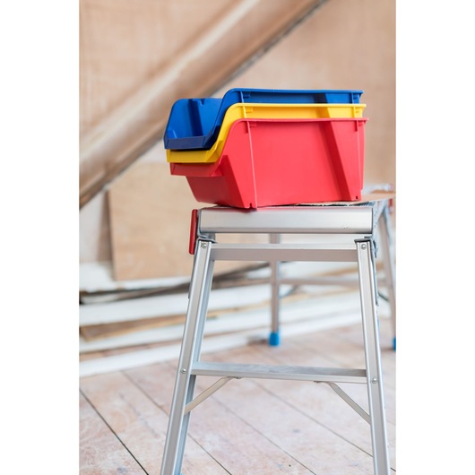 STANLEY STST82742-1 stackable plastic storage bins in red, yellow, and blue on metal workbench.