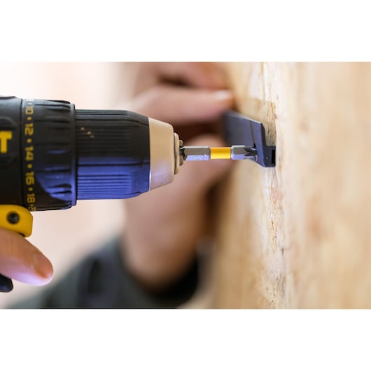 STANLEY STST82964-1 drill driver in use attaching metal bracket to wooden wall, close-up photography.