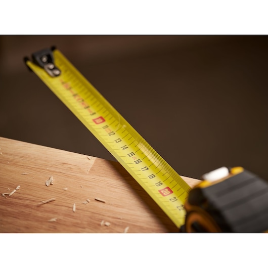 STANLEY XTHT0-33671 tape measure extended across wooden surface, close-up photography.